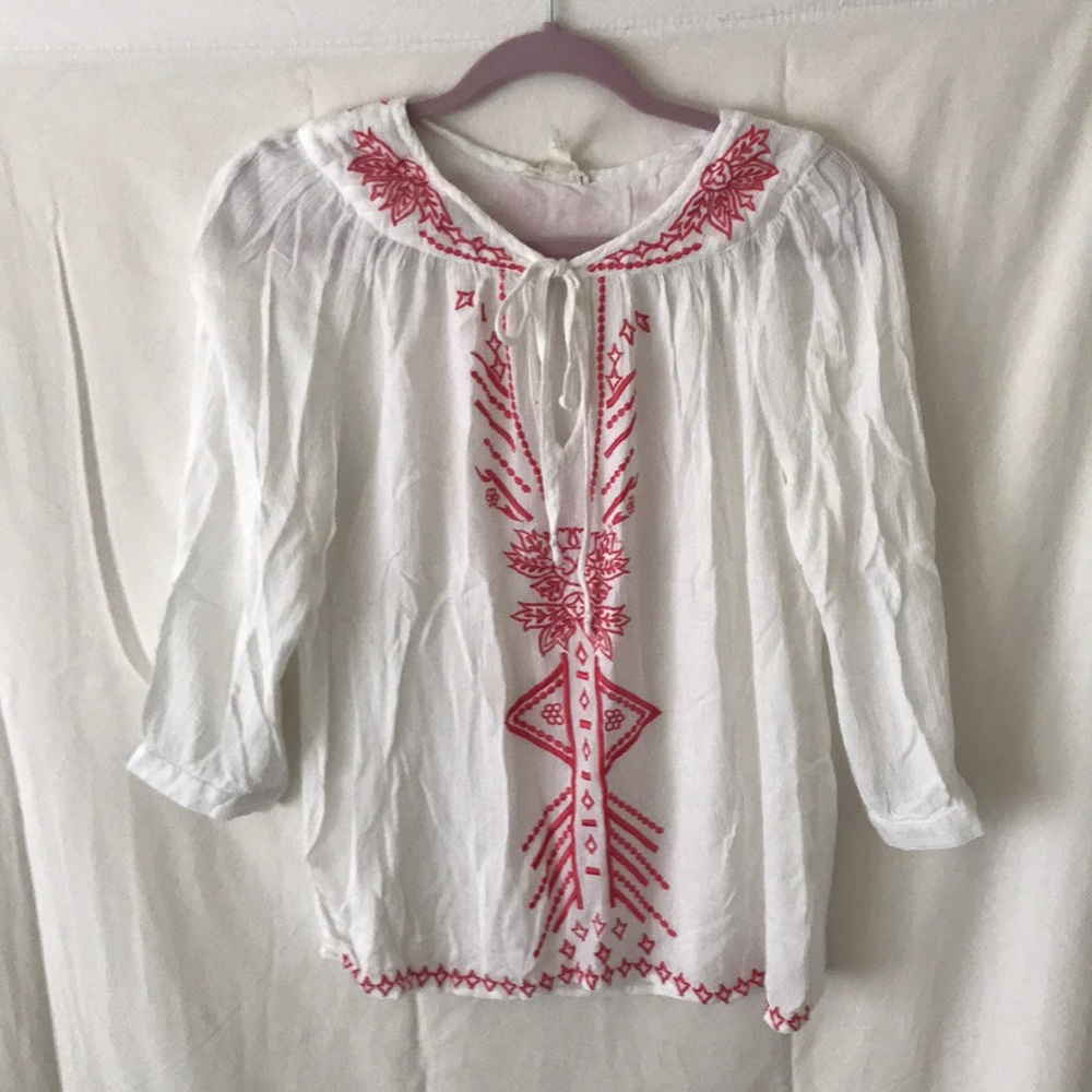 White long sleeve blouse with coral detailing.